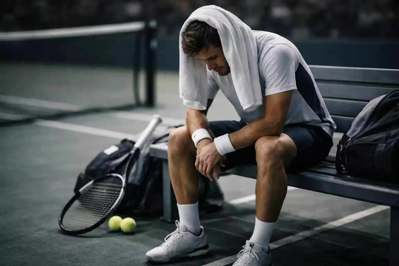 Joueur de tennis assis sur le banc avec serviette